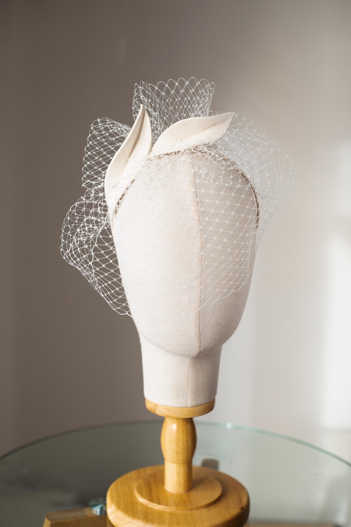 Bridal petals fascinator with short birdcage veil on beige skinny headband, ivory felt leaves head piece on netting veil