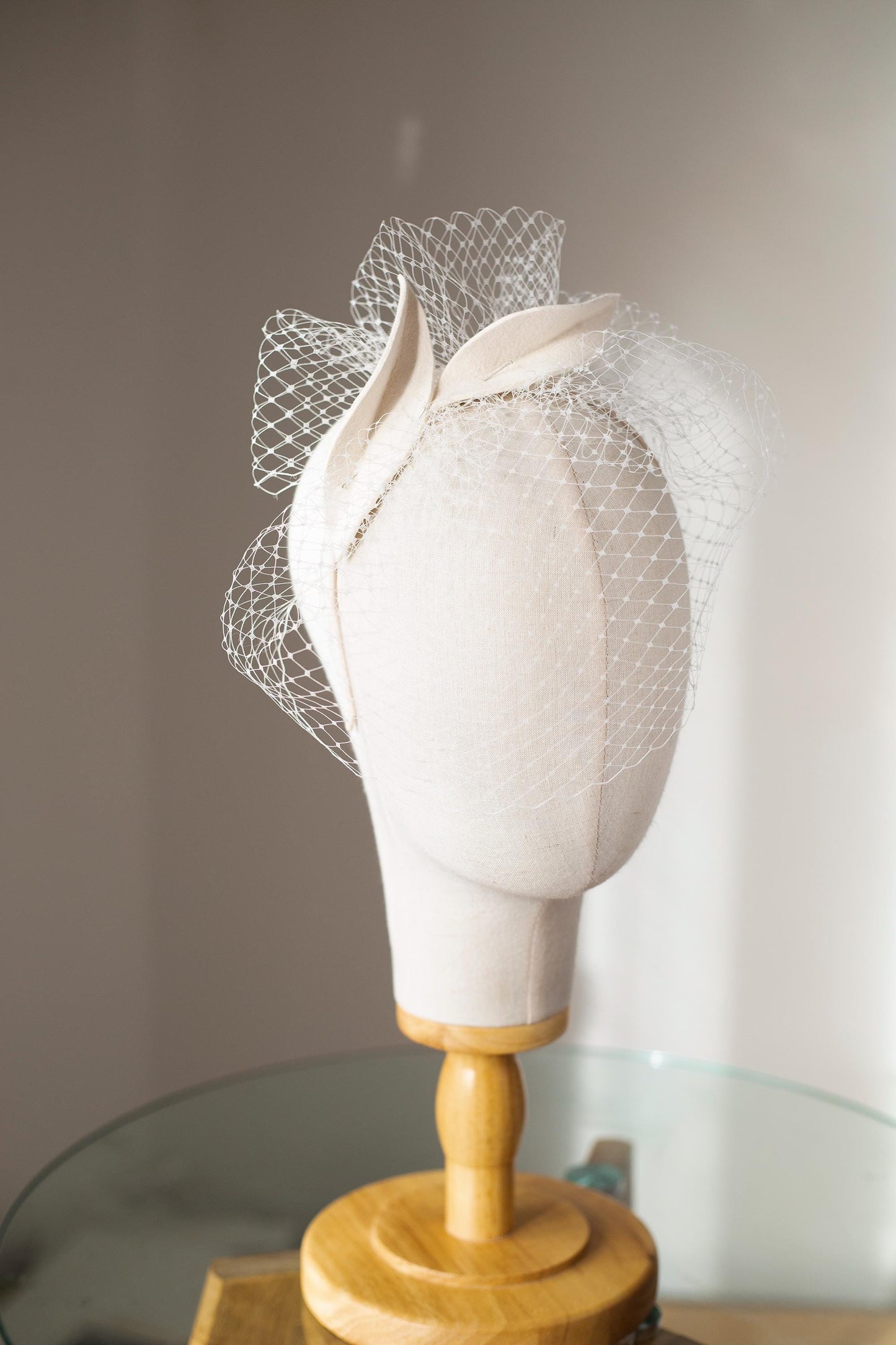 Bridal petals fascinator with short birdcage veil on beige skinny headband, ivory felt leaves head piece on netting veil