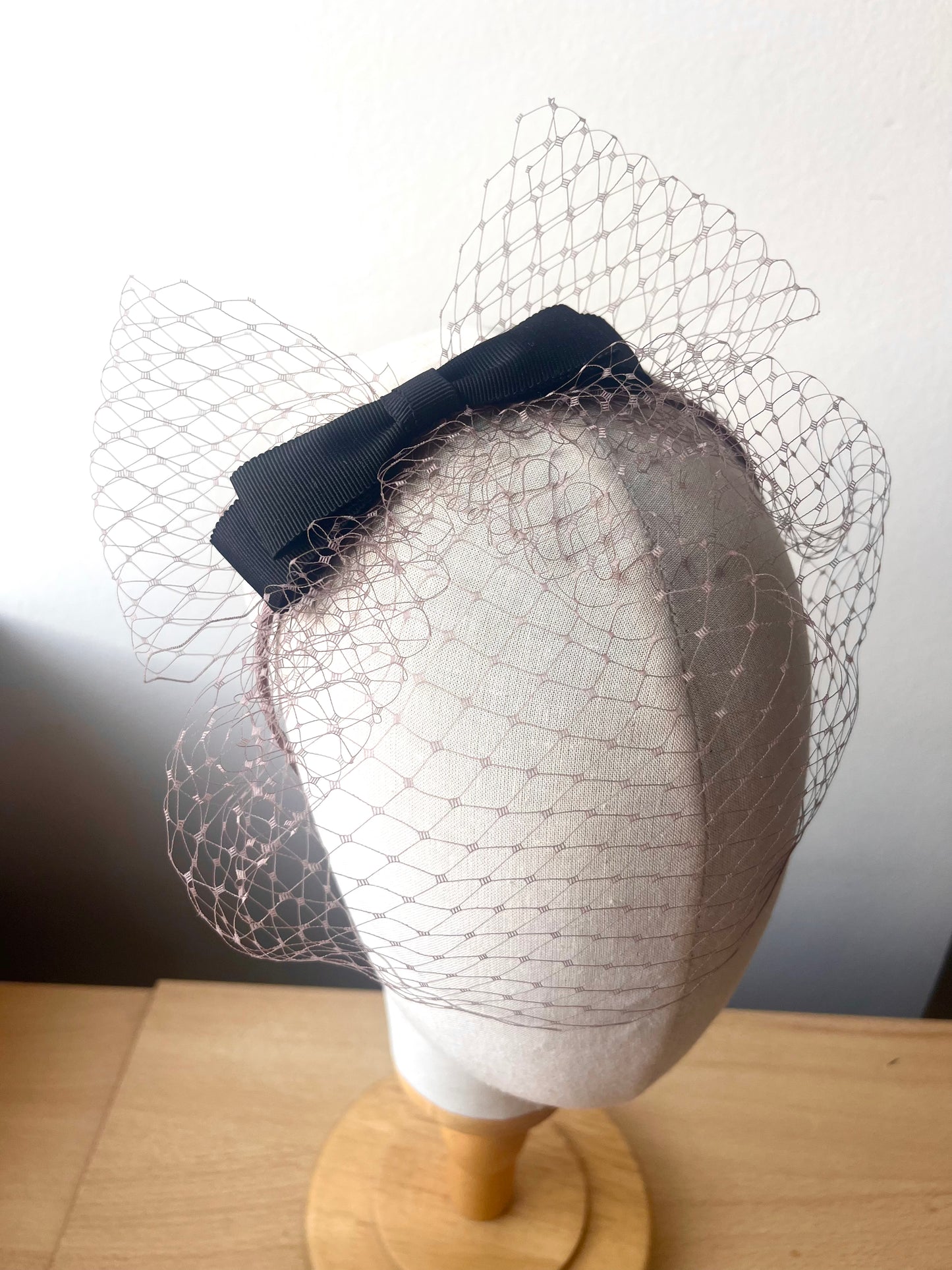 Taupe birdcage on headband with double bow in black
